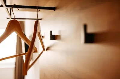 a row of wooden hangers on a wall with a window at Hotel Murat in Ptuj