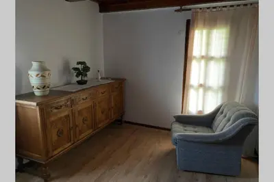 a living room with a chair and a wooden dresser at Oaza miru v sožitju z naravo in Sveti Jurij ob Ščavnici