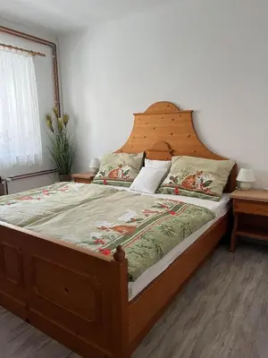 a bedroom with a large bed with a wooden headboard at Apartmaji pr' Matičo in Kranjska Gora