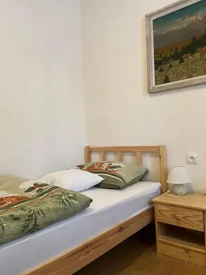 two beds in a bedroom with a picture on the wall at Apartmaji pr' Matičo in Kranjska Gora