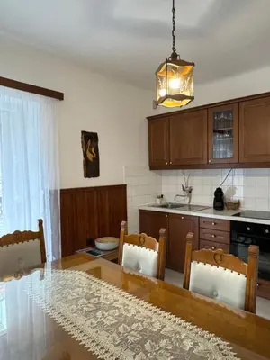 a kitchen with a wooden table and a dining room at Apartmaji pr' Matičo in Kranjska Gora