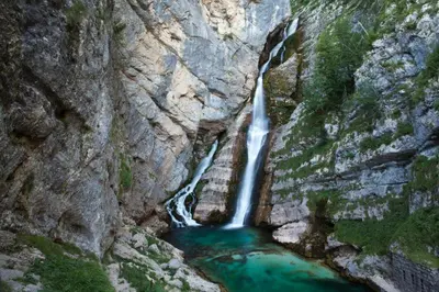 a waterfall in a rocky canyon with green water at Villa Pokljuka in Zgornje Gorje