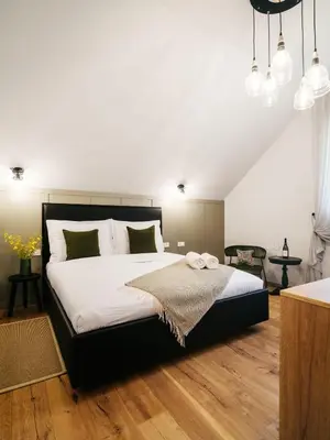 a bedroom with a large bed with white sheets at Pr Kopač in Brezovica