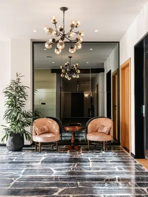 a lobby with two chairs and a table and a chandelier at Pr Kopač in Brezovica