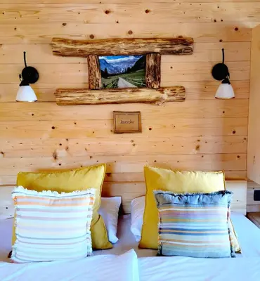 a bed with two pillows and a mirror on a wall at Ribno Luxury Glamping in Bled
