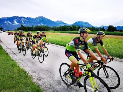 a group of men riding bikes down a road at Ribno Luxury Glamping in Bled