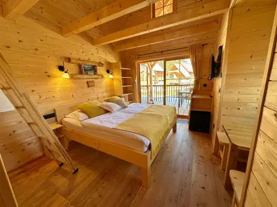 a bedroom with a bed in a wooden cabin at Ribno Luxury Glamping in Bled