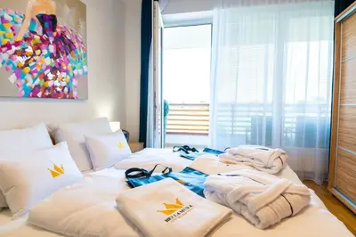 a bedroom with a bed with towels on it at Bella Mura Blue Apartment in Moravske Toplice