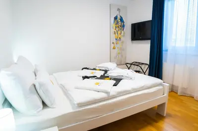 a white bed with white pillows and towels on it at Bella Mura Blue Apartment in Moravske Toplice