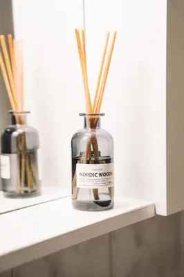 a bottle with sticks in it sitting on a shelf at V objemu gora in Bohinj