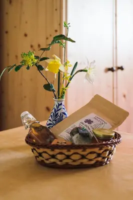 a basket on a table with a vase with flowers at V objemu gora in Bohinj