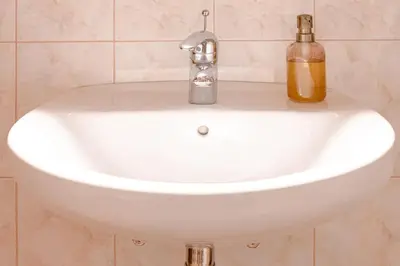 a white sink with a soap bottle on it at V objemu gora in Bohinj