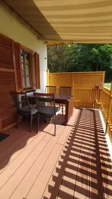 a patio with a table and chairs on a deck at Tulpika1 in Moravske Toplice