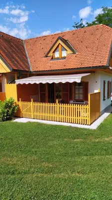 a house with a yellow fence in the yard at Tulpika1 in Moravske Toplice