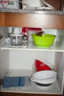 a shelf with a green bowl and dishes on it at Hišica 70 in Čatež ob Savi