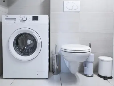 a bathroom with a washing machine and a toilet at Vigorous Bled Apartment in Bled