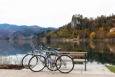 two bikes parked next to a bench next to a lake at Vigorous Bled Apartment in Bled