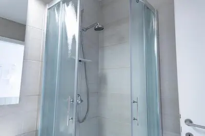 a shower with a glass door in a bathroom at Vigorous Bled Apartment in Bled