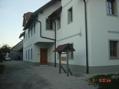 a white building with a sign in front of it at Apartments Vrdjan in Cerknica