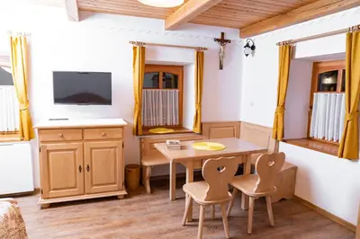 a dining room with a table and chairs and a tv at Guesthouse Močivnik in Okroglice