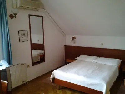a bedroom with a white bed and a mirror at Guest House Arvaj in Kranj