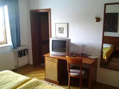 a hotel room with a desk with a tv on it at Guest House Arvaj in Kranj