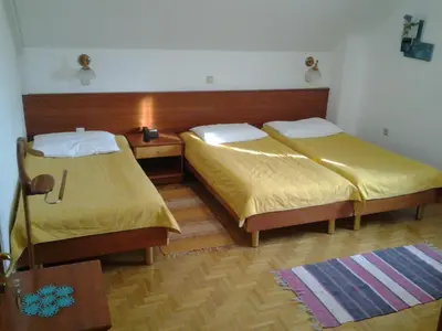 a room with two beds and a table at Guest House Arvaj in Kranj