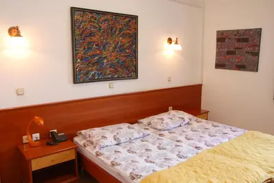 a bedroom with a bed and a picture on the wall at Guest House Arvaj in Kranj