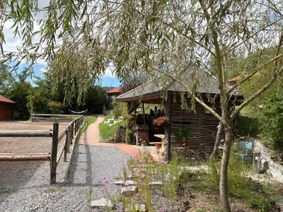 a small wooden building next to a fence at Lipizzaner Lodge Guest House in Postojna