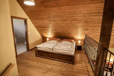a bedroom with a bed in a wooden wall at Panonska Vas Villas in Moravske Toplice
