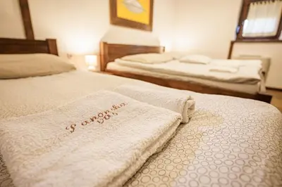 a room with two beds with white towels on them at Panonska Vas Villas in Moravske Toplice