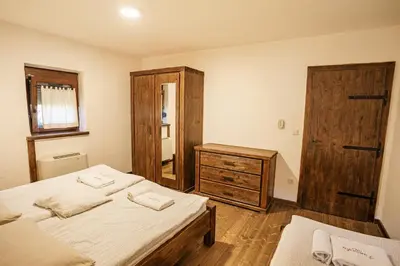 a bedroom with two beds and a wooden dresser at Panonska Vas Villas in Moravske Toplice