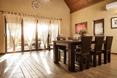 a dining room with a table and chairs and a clock at Panonska Vas Villas in Moravske Toplice