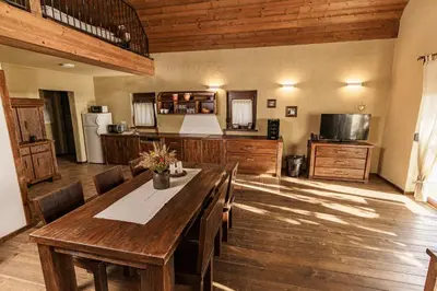a dining room with a table and a kitchen at Panonska Vas Villas in Moravske Toplice