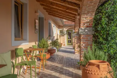 an outdoor patio with chairs and tables and a brick building at Residence Apolonija Guest House in Sežana