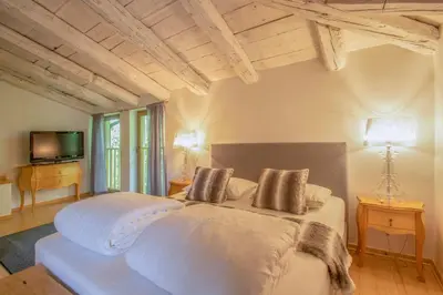 a bedroom with a large white bed and a television at Residence Apolonija Guest House in Sežana