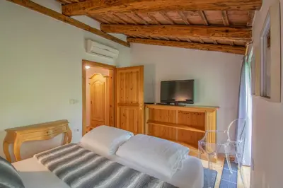 a bedroom with a white bed and a tv at Residence Apolonija Guest House in Sežana