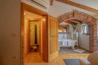 an open doorway to a bathroom with a bath tub at Residence Apolonija Guest House in Sežana