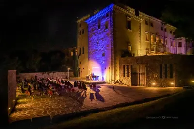 a group of people sitting outside of a building at night at Vila Vipolže - Rooms & J. Suites in Vipolže