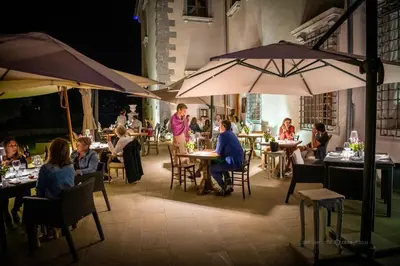 a group of people sitting at tables in a restaurant at Vila Vipolže - Rooms & J. Suites in Vipolže