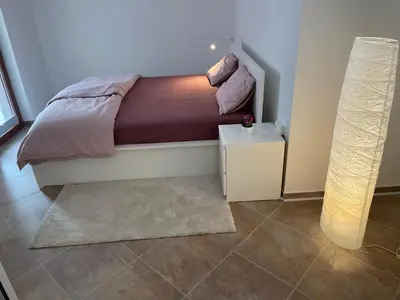 a bedroom with a bed with a night stand and a lamp at Apartma 7 - In the heart of Soča Valley in Tolmin