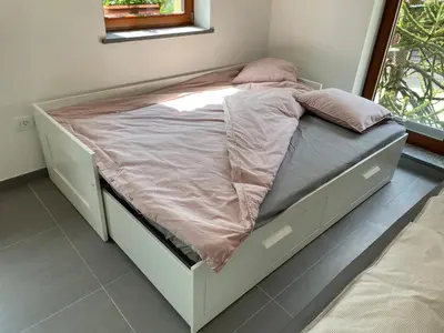 a white bed in a room with a window at Apartma 7 - In the heart of Soča Valley in Tolmin