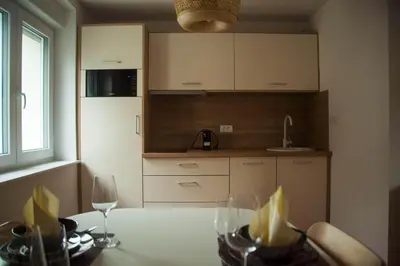 a kitchen with a table with wine glasses on it at Chang Thai apartments in Ljubljana