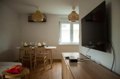 a living room with a table and a television at Chang Thai apartments in Ljubljana
