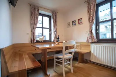 a dining room with a wooden table and chairs at Apartment Hribovc with atrium and free parking in Kranjska Gora