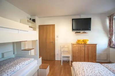 a bedroom with two beds and a flat screen tv at Apartment Hribovc with atrium and free parking in Kranjska Gora