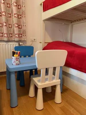 a bedroom with a bunk bed and a table and a chair at Apartment Hribovc with atrium and free parking in Kranjska Gora