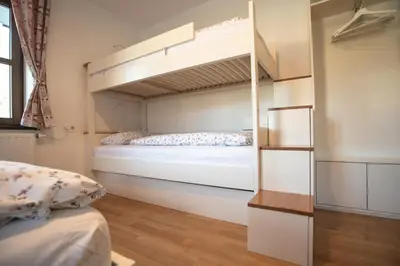 a bedroom with a bunk bed and a mirror at Apartment Hribovc with atrium and free parking in Kranjska Gora