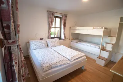 a bedroom with two beds and a window at Apartment Hribovc with atrium and free parking in Kranjska Gora