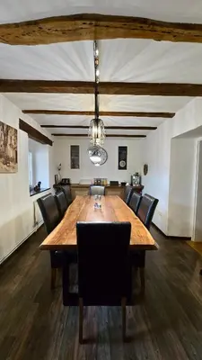 a dining room with a large wooden table and chairs at Hisa Brdo Guesthouse in Tolmin